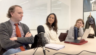 Some people sitting around a microphone